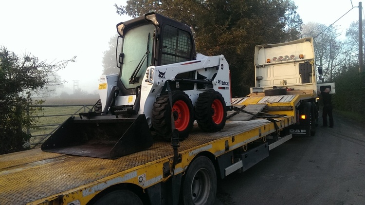 Construction Vehicles on a flat bed truck, waiting to be shipped.