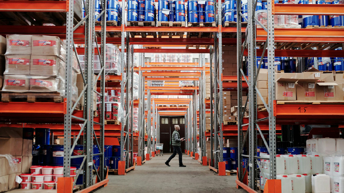 Car shipping company warehouse with vehicle parts and shipping vehicles.